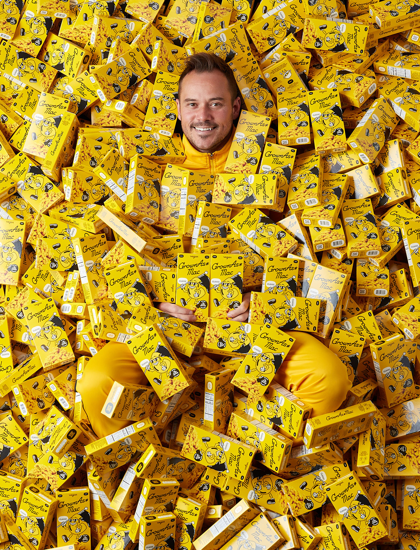 Portrait of man in pit of mac and cheese boxes