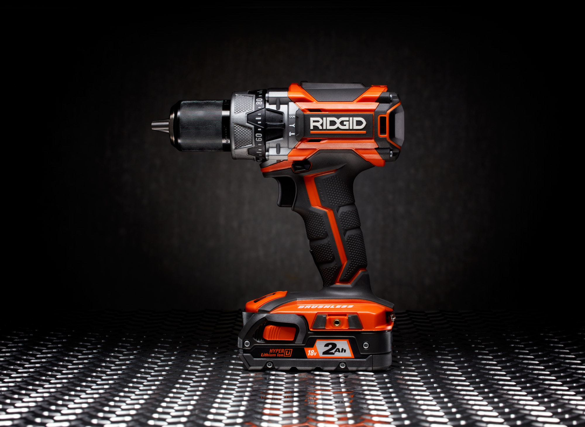 RIDGID-Drill studio product photo on diamond plate with concrete wall in background.