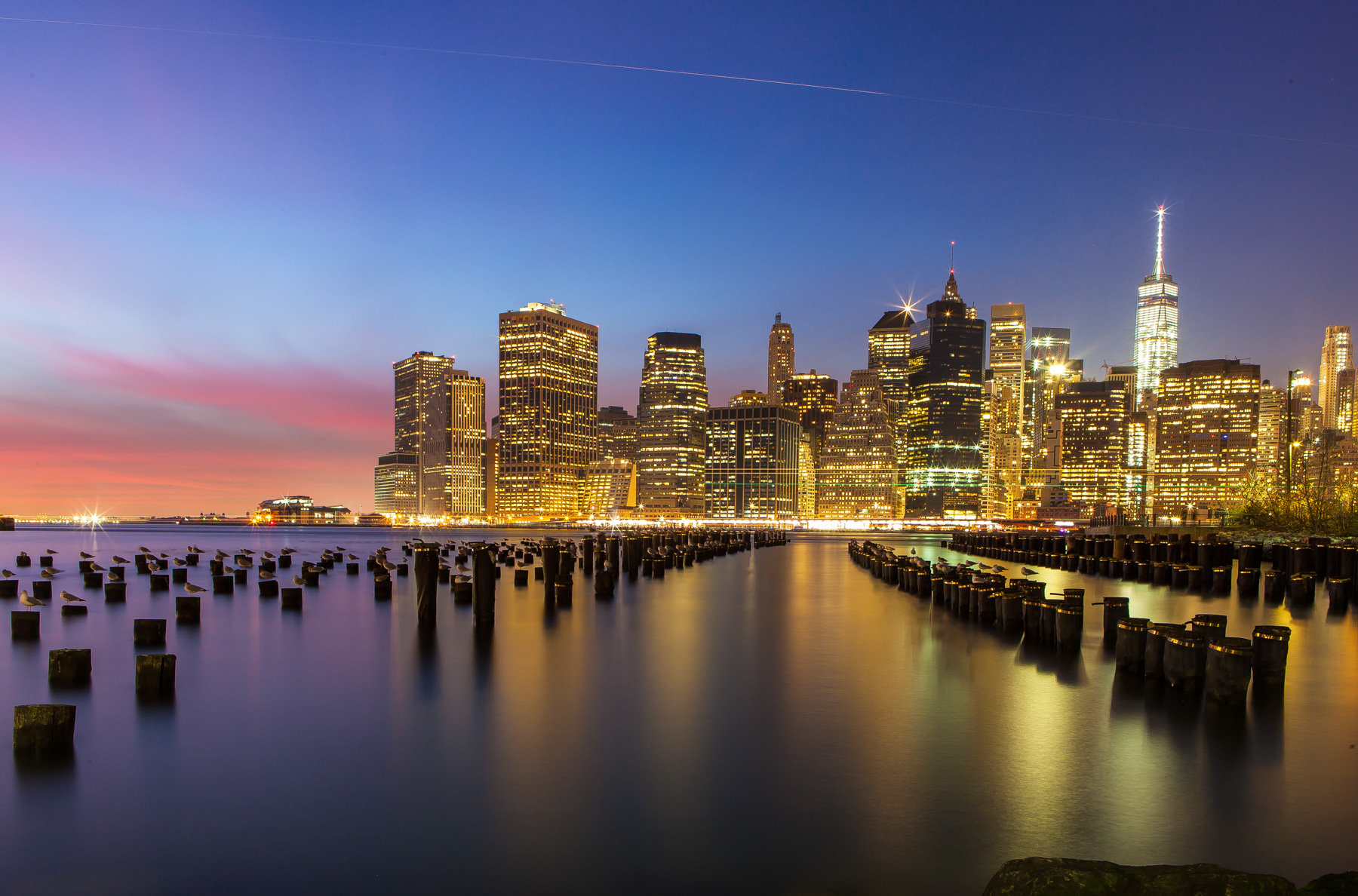 Manhattan skyline from Brooklyn Bridge Park at dusk in New York City.