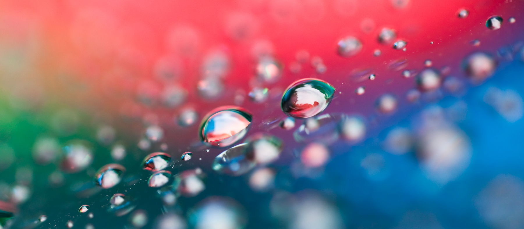 Macro Fine Art photo of water droplets reflecting color off a car windshield.