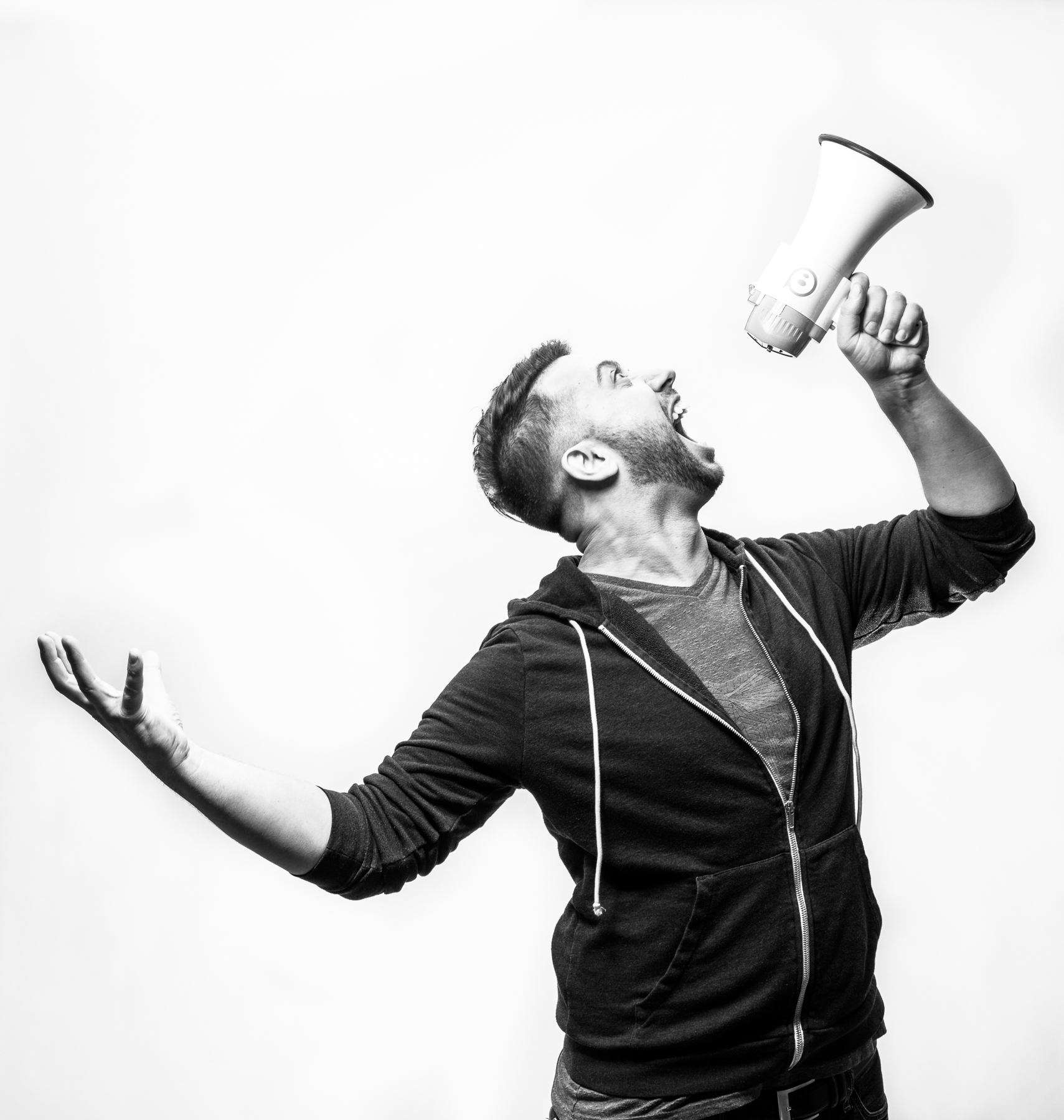 Studio portrait of man shouting into a megaphone in Boulder, Colorado.